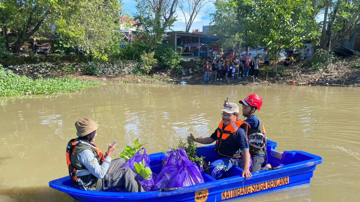 Warga dan Pemerinta daerah menggunakan salah satu bantuan PLN yaitu perahu Fiber untuk menyeberang sungai dalam kegiatan penanaman 400 pohon di Kelurahan Katimbang