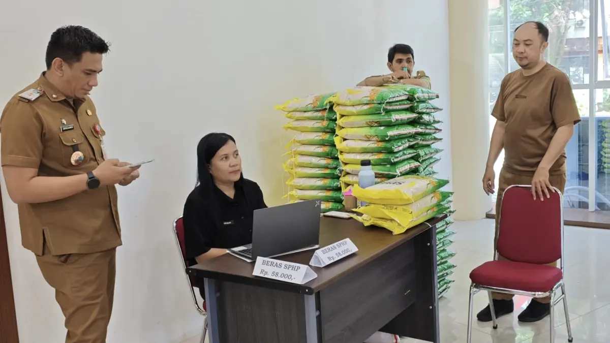 Tekan Inflasi-Kepala Dinas Pangan Minahasa Utara Asriyadi Lalompo bersama personil saat menggelar penjualan beras murah di MPP Minut. 

