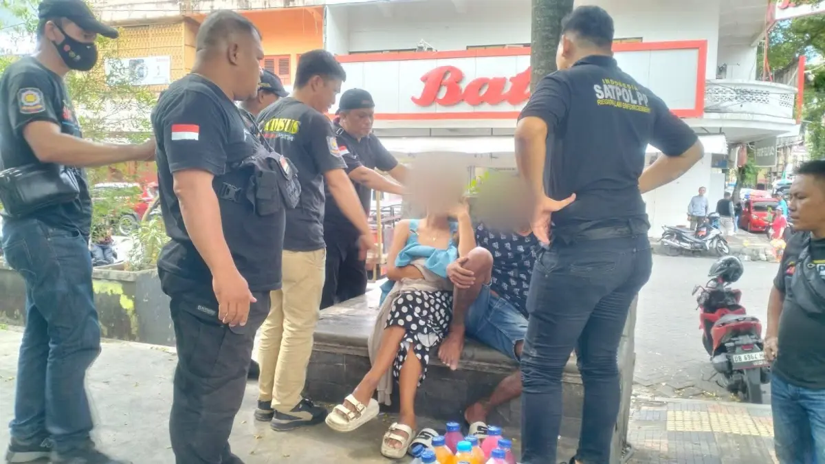 TEGAS: Personel Sat Pol PP Manado ketika mengamankan sepasang kekasih sedang menghirup lem eha bond di Wilayah TKB, Kamis (21/5)