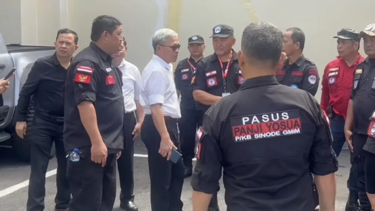 Eks Plt Ketua Sinode GMIM Pdt Janny Rende usai diperiksa di Mapolda Sulut. Tampak dikawal Panji Yosua GMIM