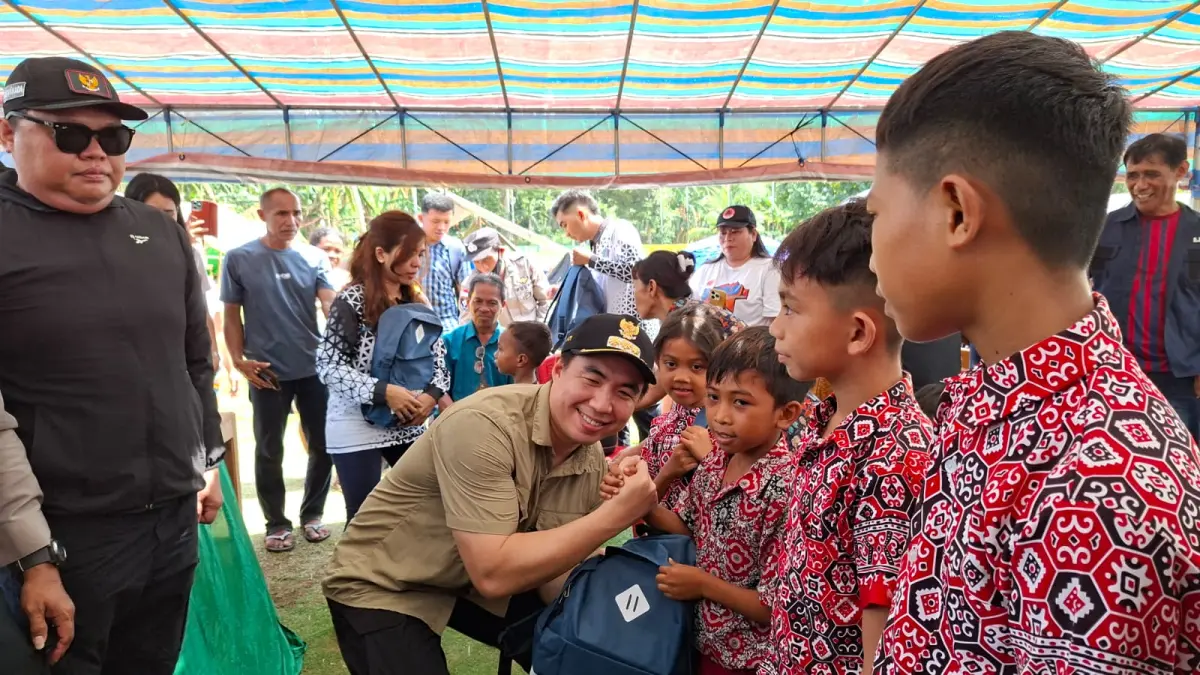 Bupati Michael Thungari didampingi Wakil Bupati Tendris Bulahari menyerahkan bantuan kepada anak - anak korban bencana di Kampung Kawio, Kecamatan Marore Kabupaten Sangihe, Kamis (11/6/26).