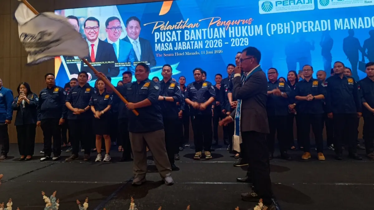 Ketua PBH Peradi Manado Handri Piter Poae saat menerima pataka dari Ketua PBH Peradi Pusat Suhendra Hutabarat 