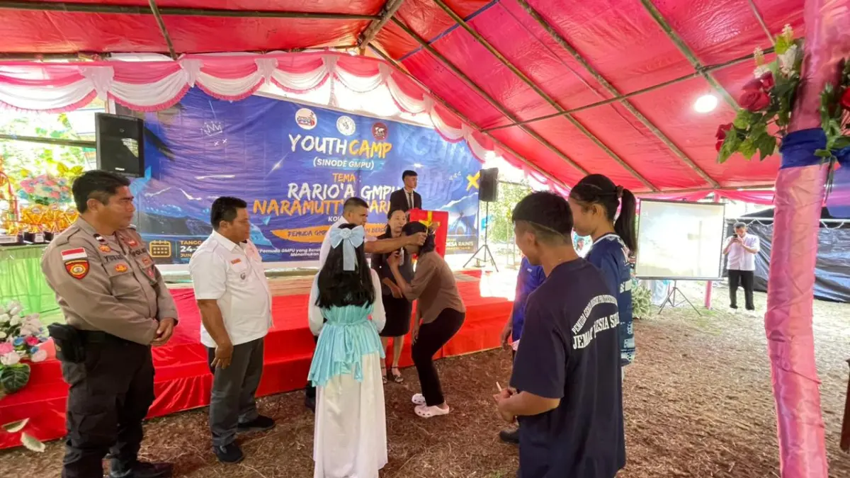 Asisten 1 Pemkab Talaud Daud Malensang saat memasangkan tanda peserta secara simbolis dalam acara pembukaan. 
