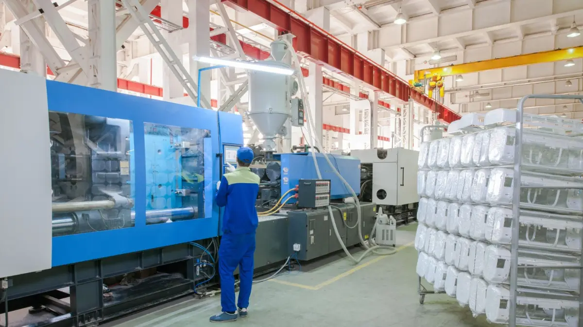 Mesin press injection molding industri untuk memproduksi komponen Air Conditioner menggunakan polimer.
