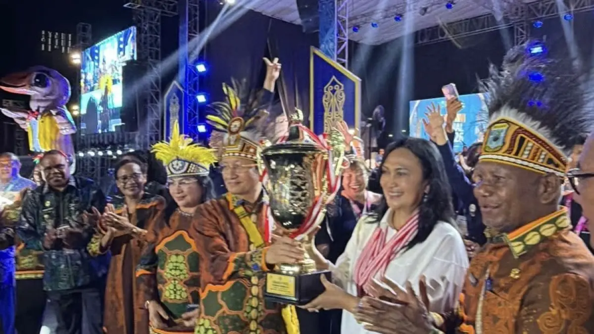 Ketua Umum Lembaga Pengembangan Pesparawi Daerah (LPPD) Sulawesi Utara Anik Yulius Selvanus saat menerima piala.