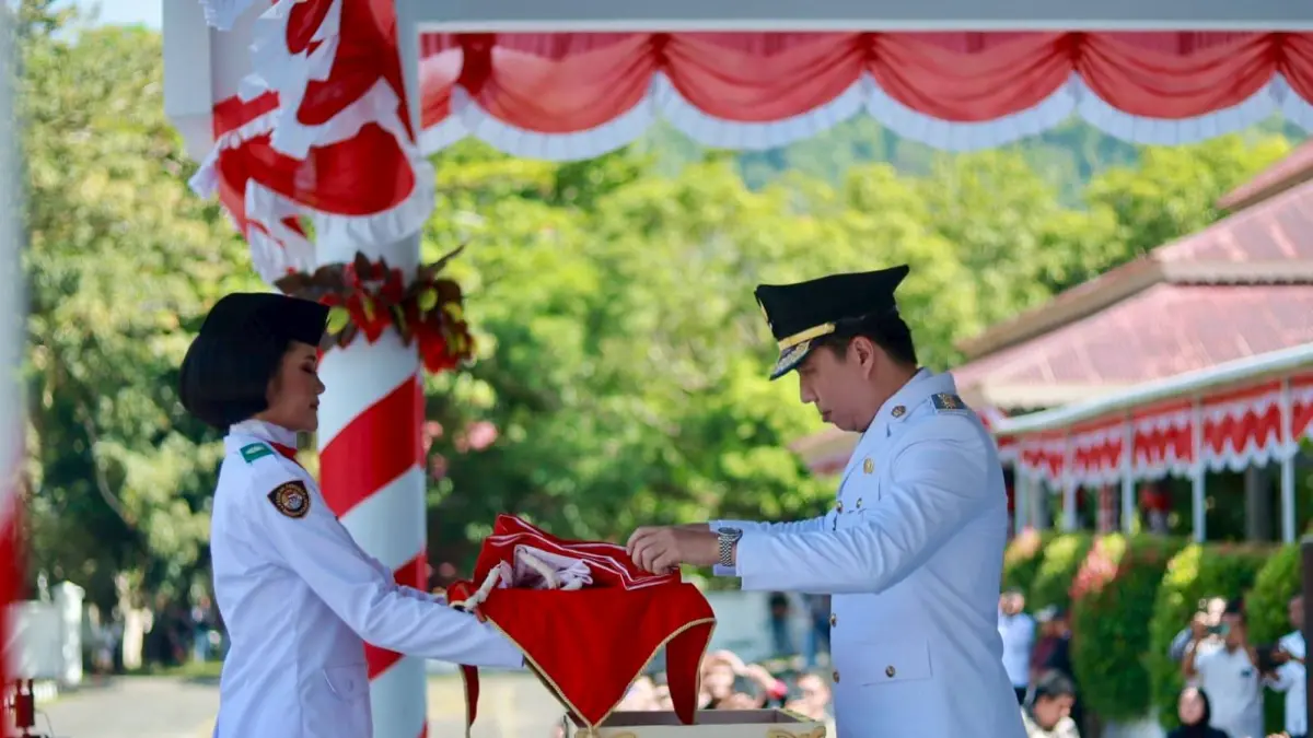 Bupati Michael Thungari menyerahkan bendera merah putih kepada pembawa baki untuk selanjutnya dikibarkan pada upacara peringatan HUT kemerdekaan RI ke 81 di Kabupaten Kepulauan Sangihe, Senin (17/8/26).