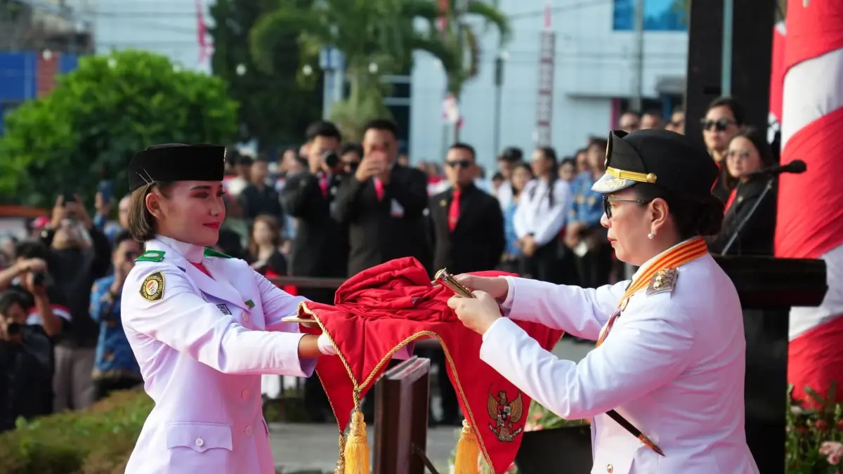 TERIMA: Wabup Vanda Sarundajang saat menerima bendera merah putih dari Paskibraka pada Upacara Penurunan Bendera di Lapangan Sam Ratulangi Tondano, Senin (17/8/2026) sore.
