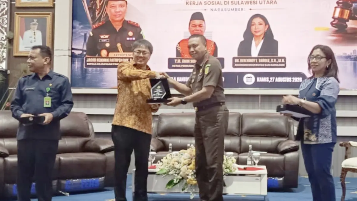 Kajati Sulut Jacob Hendrik Pattipeylohy SH MH memberikan cindera mata ke Wali Kota Manado Andrei Angouw dalam acara Seminar Hukum, Kamis (27/8) di Aula Serbaguna Pemkot Manado