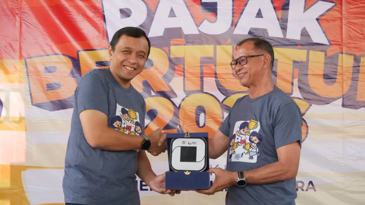 Kepala Kanwil DJP Suluttenggomalut, Ardiyanto Basuki saat menberikan Cendera Mata kepada pihak sekolah SMPN 1 Manado.