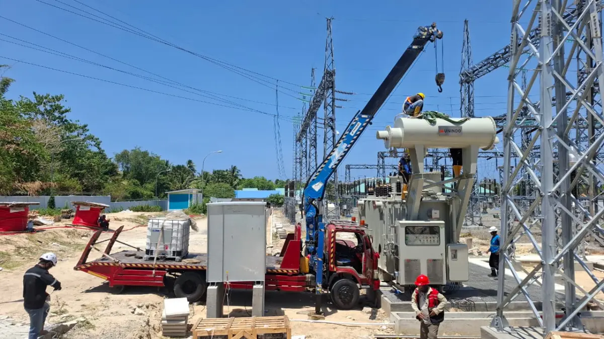 Petugas PLN menggunakan kendaraan crane khusus untuk memasang komponen Transformator Daya (Trafo) 30 MVA di Gardu Induk Marisa.