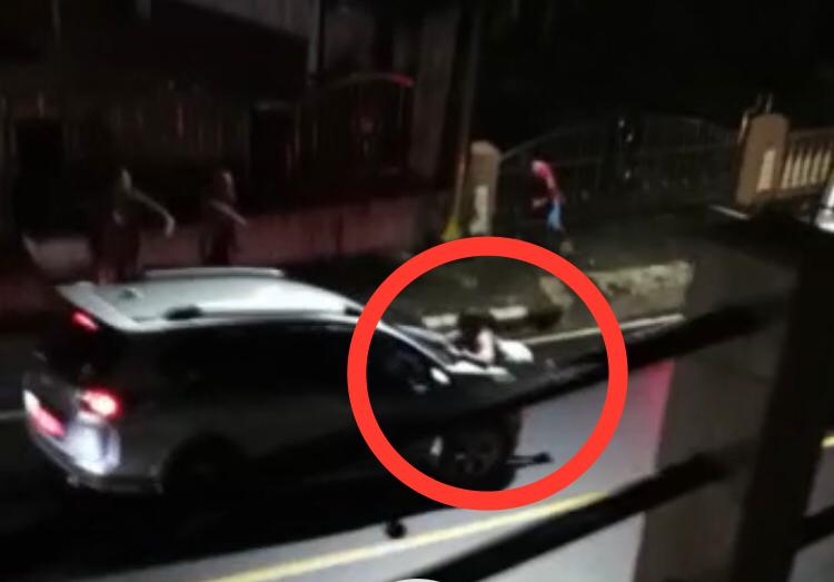 Perempuan Berkaos putih diduga MEP, saat diseret sebuah mobil di Jalan Raya Kelurahan Tumatangtang Kecamatan Tomohon Selatan.