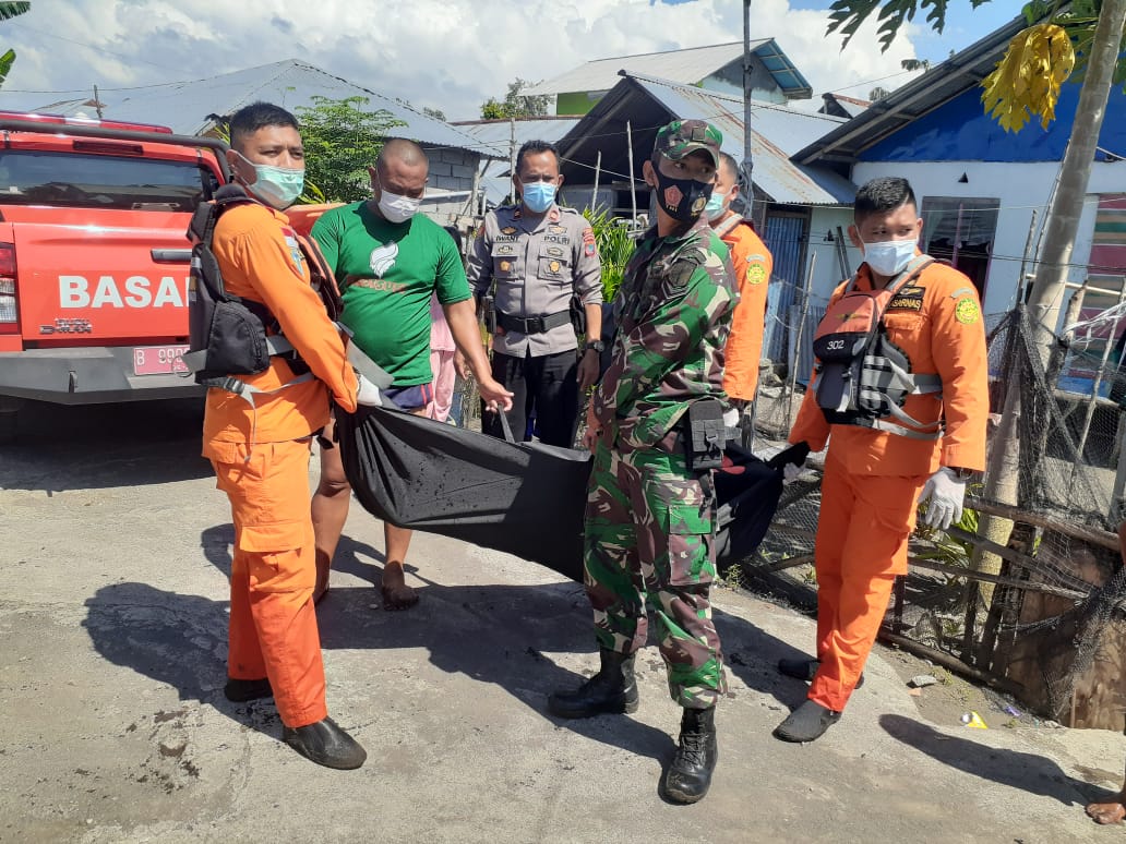 Petugas gabungan mengangkat mayat korban dari Pantai Likupang untuk dievakuasi. 