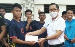 Ketua Askot PSSI Tomohon Gerard Lapian SE MAP (kanan) membantu pesepakbola muda berbakat, Savior Da’wan (kiri) yang akan mengikuti tahapan Seleksi Tim Nasional PSSI U-16.
