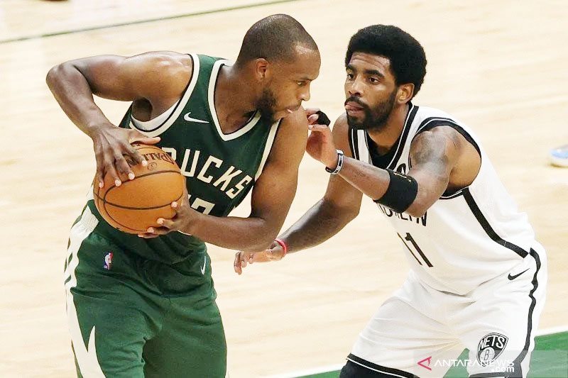 Guard Brooklyn Nets Kyrie Irving (kanan) berupaya merebut bola dari pemain Milwaukee Bucks Khris Middleton saat pertandingan NBA kedua tim di Milwaukee, Wisconsin, Minggu (2/5/2021). Foto: Getty Images via AFP/STACY REVERE