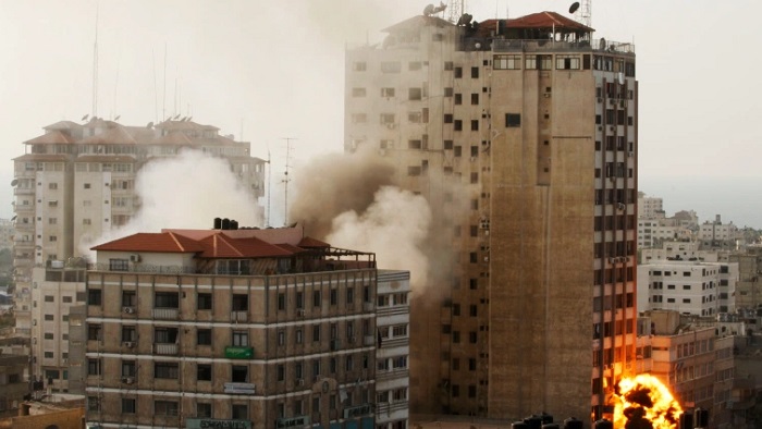 Asap dan api terlihat setelah serangan udara di gedung tempat media-media internasional berkantor di Kota Gaza (AP Photo/Hatem Moussa)