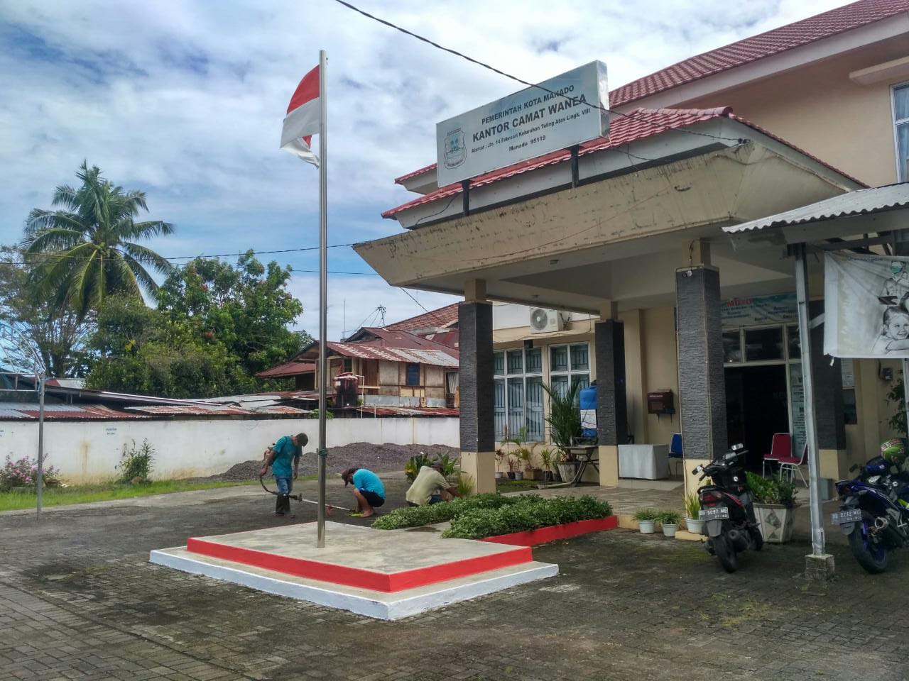 Pegawai kecamatan membersihkan sampah