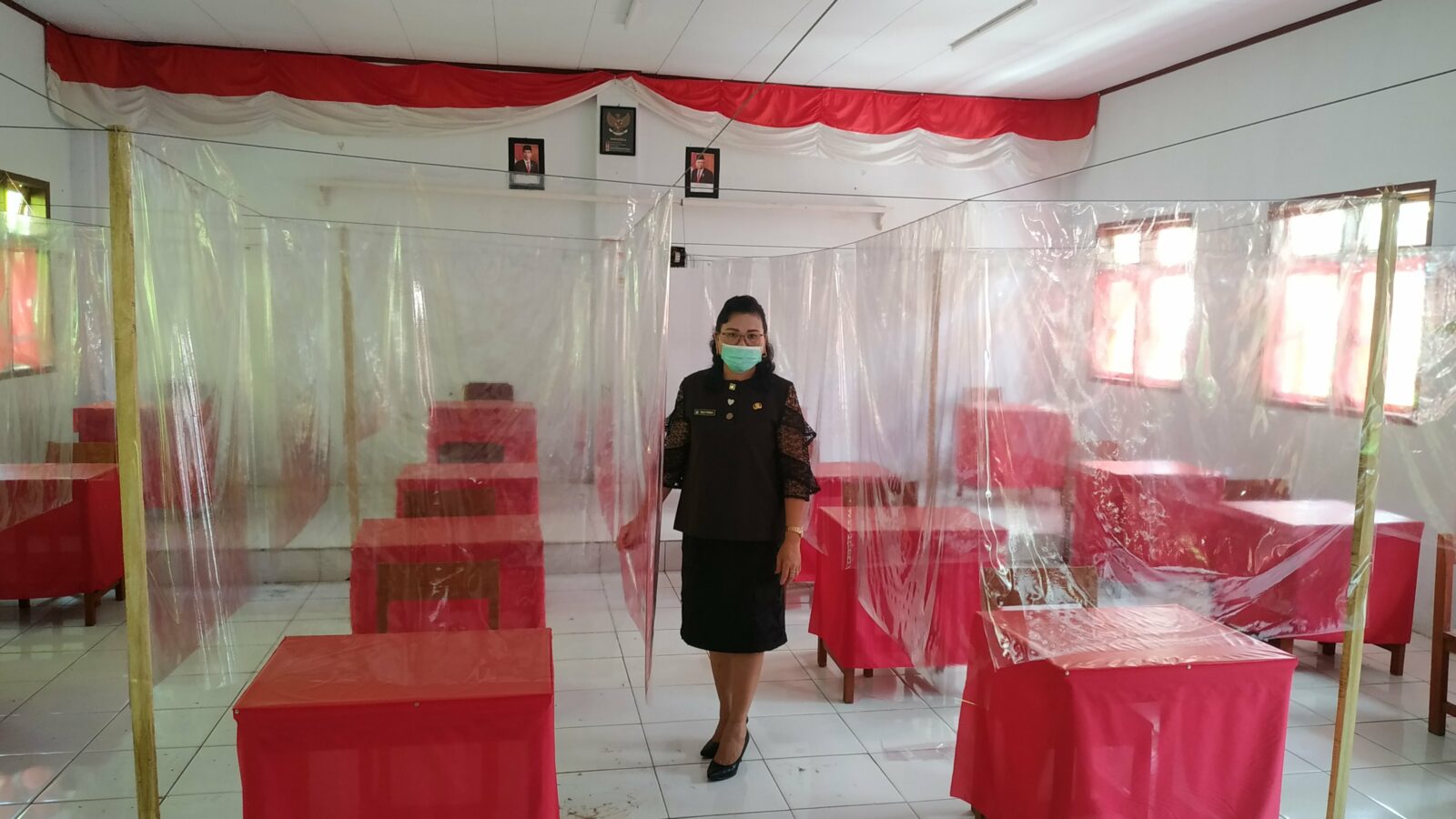 Kepala SMK Negeri 1 Amurang menunjukan salah satu kelas yang sudah dipasang sekat plastik untuk pembelajaran tatap muka terbatas.