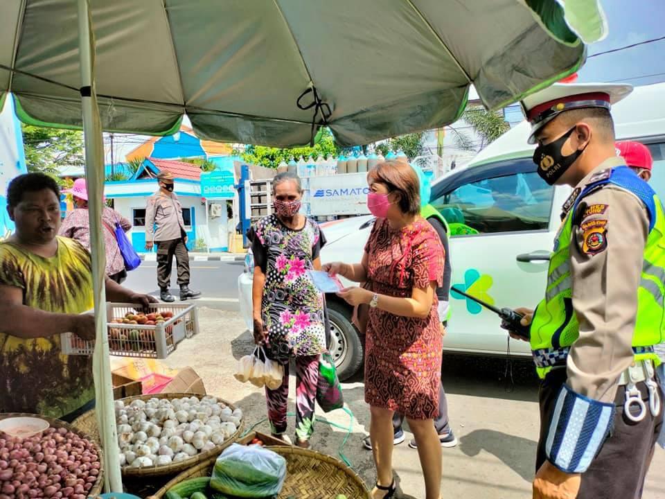 Kepala Puskesmas Girian Weru dr Lanny Mamahit bersama jajaran Polres Bitung, saat membagikan masker kepada pedagang di Pasar Girian. (Istimewa)