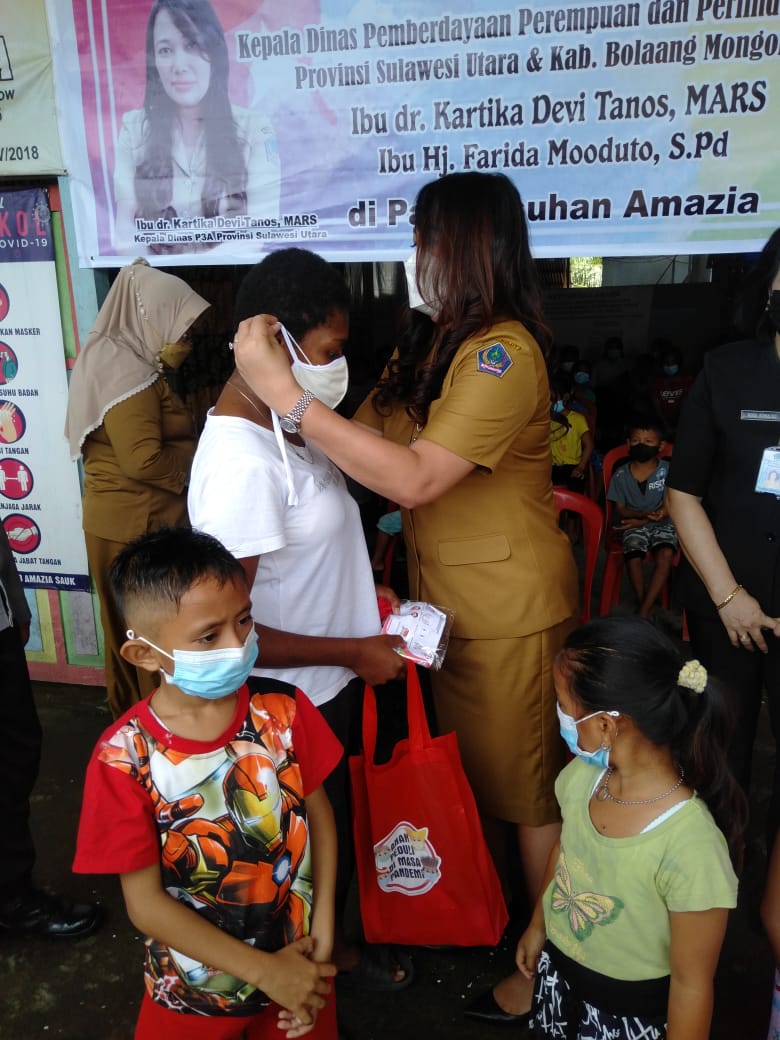 PEDULI: Kepala Dinas Pemberdayaan Perempuan dan Perlindungan Anak Daerah Sulut dr Kartika Devi Kandouw-Tanos saat memakaikan masker kepada salah satu anak yang tinggal di Panti Asuhan Amazia, Bolmong. (Balladewa/MP)