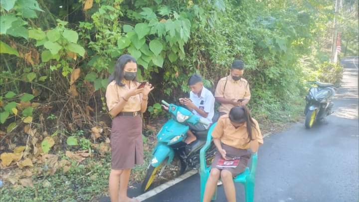 Pelajar di Kelurahan Pasir Panjang, Kecamatan Lembeh Utara, mencari signal di lokasi perkebunan.(Istimewa)