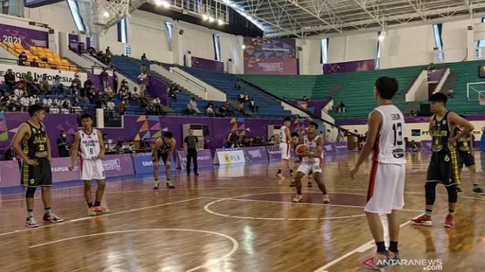 Tim bola basket 5x5 putra Sulawesi Utara (seragam putih) bertanding menghadapi Jawa Timur dalam laga Pool Y PON XX Papua di Mimika Sport Complex, Mimika, Kamis (30/9/2021). Sulawesi Utara memenangkan pertandingan tersebut dengan skor 76-72. (ANTARA/Michae