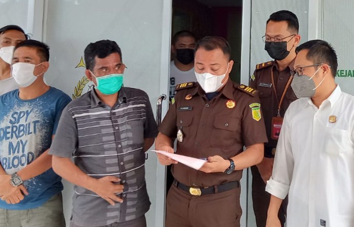  Kasie Barang Bukti Kejaksaan Kotamobagu Horas Erwin Siregar, Kacabjari Kotamobagu di Dumoga Edwin Tumundo, bersama tersangka AM (masker biru). (Romansyah/MP)