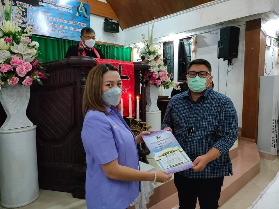 SELAMAT MELAYANI: Ketua KPRS GMIM Pnt dr Michaela Elsiana Paruntu (kiri) menyerahkan SK panitia kepada Rio Dondokambey sebagai Ketua Umum Panitia Remaja Teladan Sinode Tahun 2021, yang dilantik dalam ibadah dipimpin Ketua BPMS GMIM Pdt Hein Arina, Kamis (
