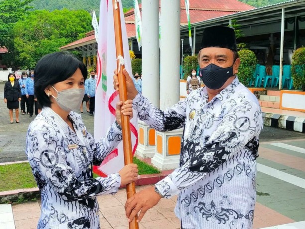 Bupati Jabes saat menyerahkan Panji PGRI kepada Ketua Umum PGRI Kabupaten Sangihe Yulien Manangkalangi. (Istimewa)