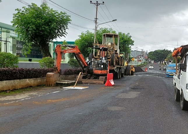 DIPERBAIKI: Tampak alat berat dan material telah dipersiapkan untuk perbaikan jalan rusak di depan Kodam XIII/Merdeka.