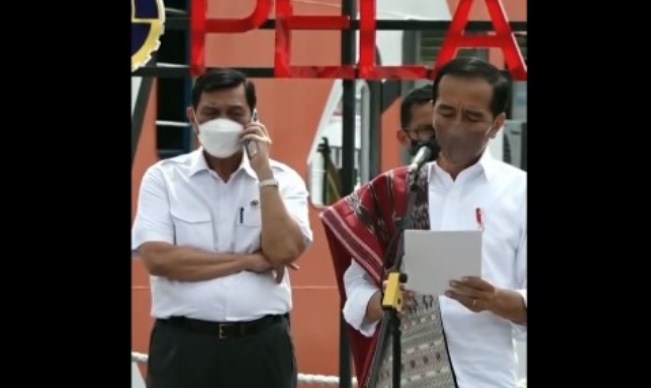 Luhut Binsar Panjaitan menerima telpon saat Presiden Joko Widodo pidato.