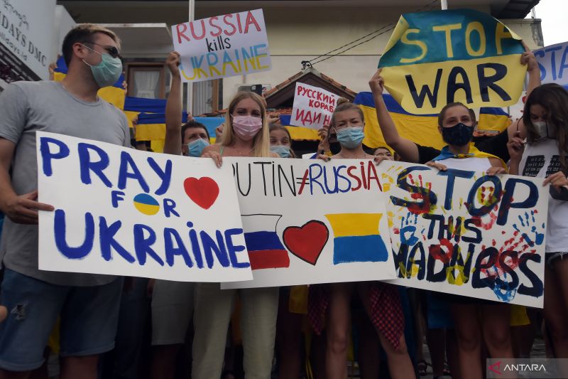 Ratusan warga negara asing (WNA) asal Ukraina bersama simpatisan meneriakkan yel-yel dan memajang tulisan saat aksi damai di Kantor Konsulat Ukraina, Denpasar, Bali, Selasa (1/3/2022). (ANTARA FOTO/Nyoman Hendra Wibowo/rwa) 