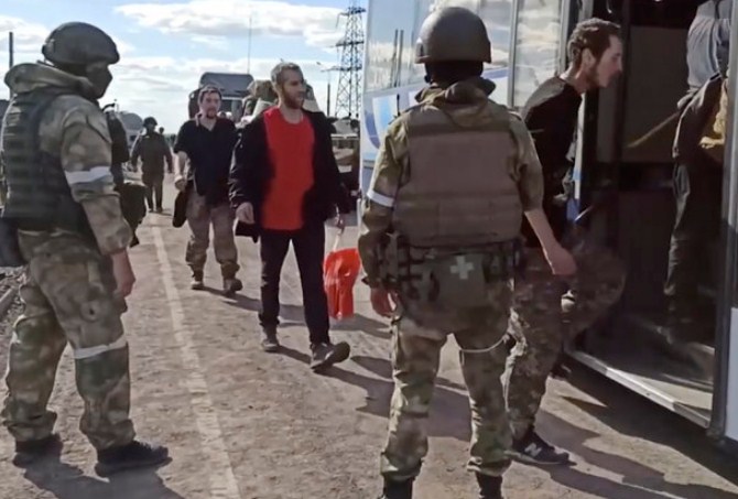 Tentara Ukraina menyerah kepada pasukan Rusia. Mereka kemudian diminta masuk ke dalam bus yang akan membawa ke penampungan (AP)