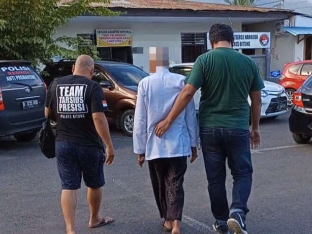 Terduga pelaku (tengah) saat tiba di Mapolres Bitung untuk menjalani pemeriksaan.(Franky Sumaraw)