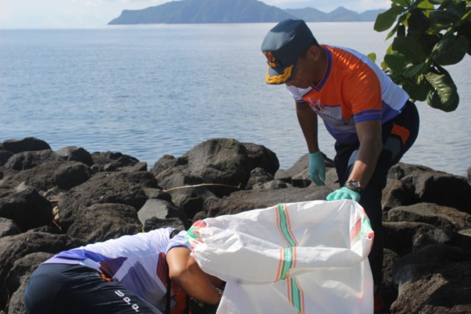 BERSIH: Kepala Syahbandar Ulu Siau Welhelmus Dami bersama Anggota TNI AL gelar bersih-bersih pantai, di Boulevard Ulu Siau, Kecamatan Siau Timur (Sitim), Jumat (9/9). (Istimewa)