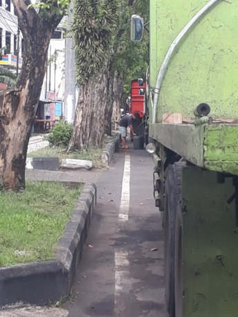 Nampak salah satu oknum sedang menghisap solar dari tangki truk saat antre di pinggir jalan dekat SPBU Kadoodan. (Istimewa)