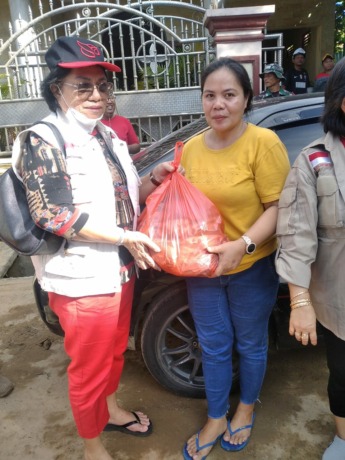 Ketua Baguna Sulut Adriana Dondokambey menyerahkan bantuan pada warga.