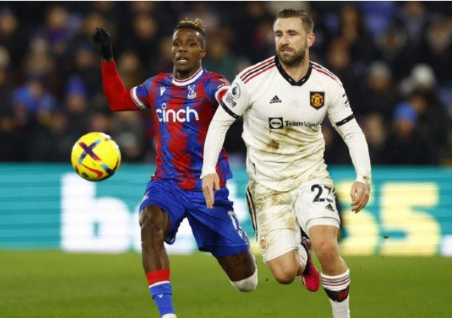 Pemain Manchester United Luke Shaw berduel memperebutkan bola dengan penyerang Crystal Palace Wilfred Zaha dalam pertandingan Liga Inggris di Selhurst Park, London, pada 19 Januari. (Peter Cziborra/Reuters/Antara)
