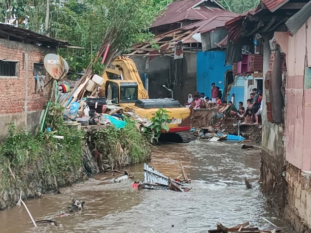 NORMALISASI: Tampak alat berat yang sementara bekerja melaksanakan pengerukan dan pelebaran sungai. Meski demikian, pekerjaan sempat terhenti karena ada warga yang tidak ingin rumahnya dibongkar.