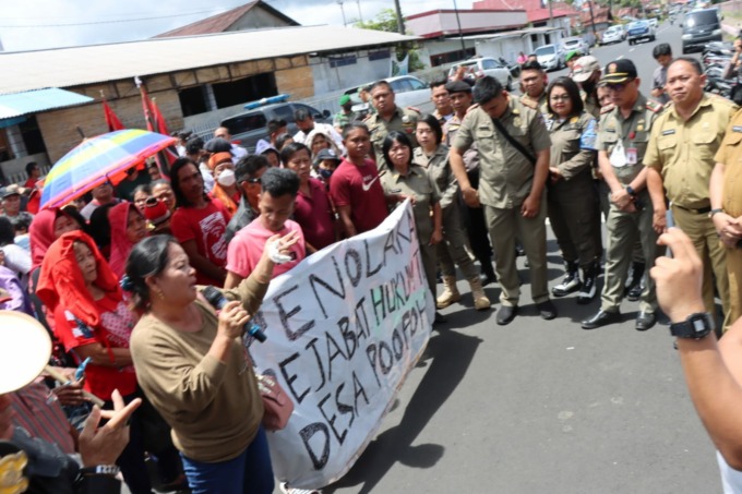 Puluhan masyarakat Desa Poopoh Kecamatan Tombariri saat menyerbu melayangkan protes terkait pelantikan Pj Hukum Tua yang baru dilantik. Terlihat masyarakat datang membawa baliho penolakan di Kantor Bupati Minahasa, Senin (13/2) siang.