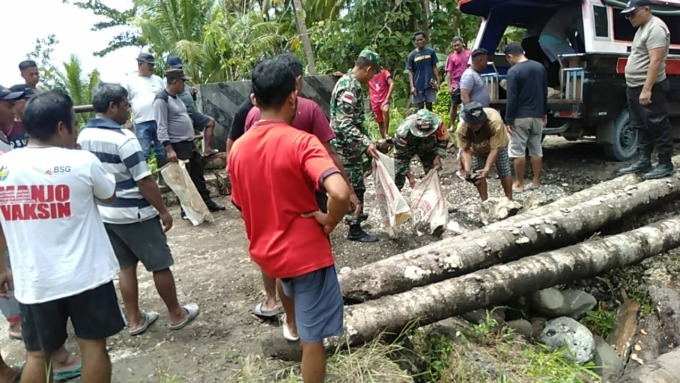Anggota Koramil 1312-01/Kabaruan bersama masyarakat saat membangun jembatan darurat (Istimewa)