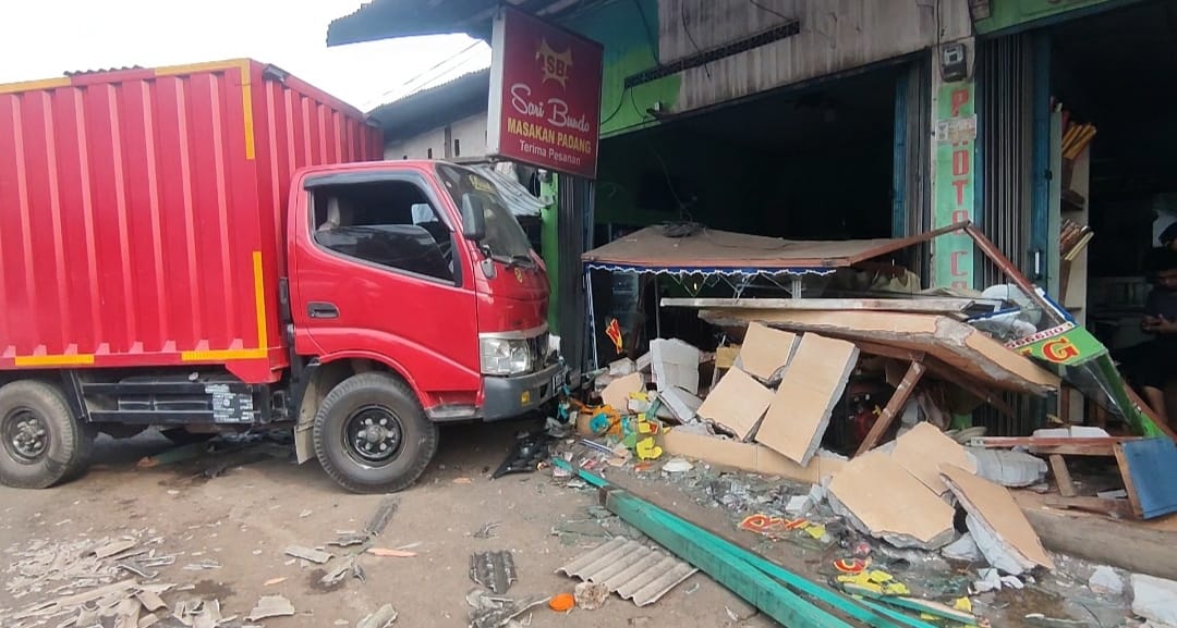 Kecelakaan di Bogor, sebuah truk Dyna menabrak lapak pedagang helm dan rumah makan padang.