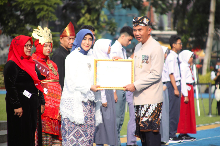 Pj. Gubernur Provinsi Jawa Barat menyerahkan penghargaan kepada Kepala SMAN 2 Cibinong Kabupaten Bogor, Elis Nurhayati dalam upacara Hardiknas)se-Provinsi Jawa Barat, di Lapangan Sempur Kota Bogor.