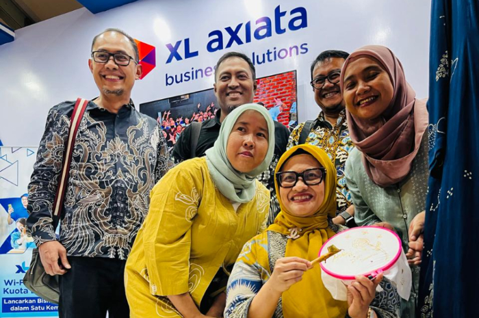 Presiden Direktur & CEO XL Axiata, Dian Siswarini (duduk) mencoba membatik di booth XL Axiata di arena Pameran HUT ke-44 Dekranas di Surakarta, Sabtu (18/5).