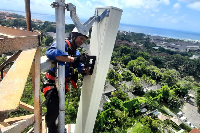 Petugas XL Axiata tengah memasang perangkat jaringan.