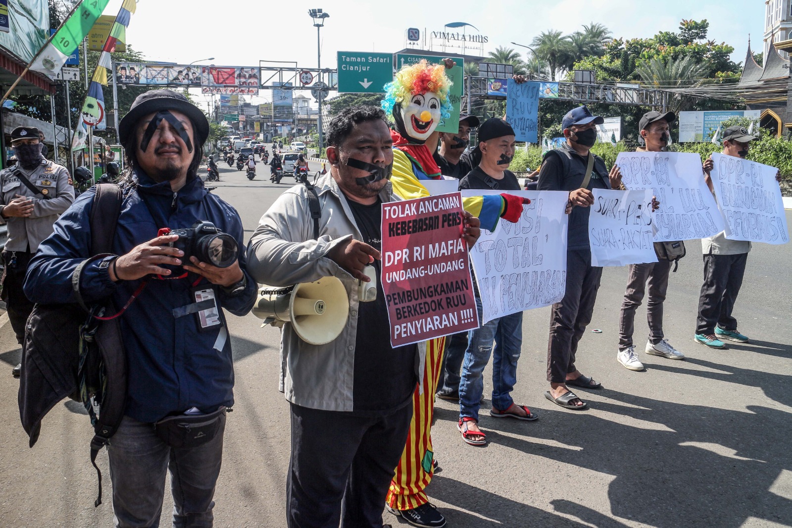 Sejumlah awak media menggelar aksi teatrikal di Jalan Raya Puncak, Kecamatan Ciawi, Kabupaten Bogor, Minggu (26/5/2024).