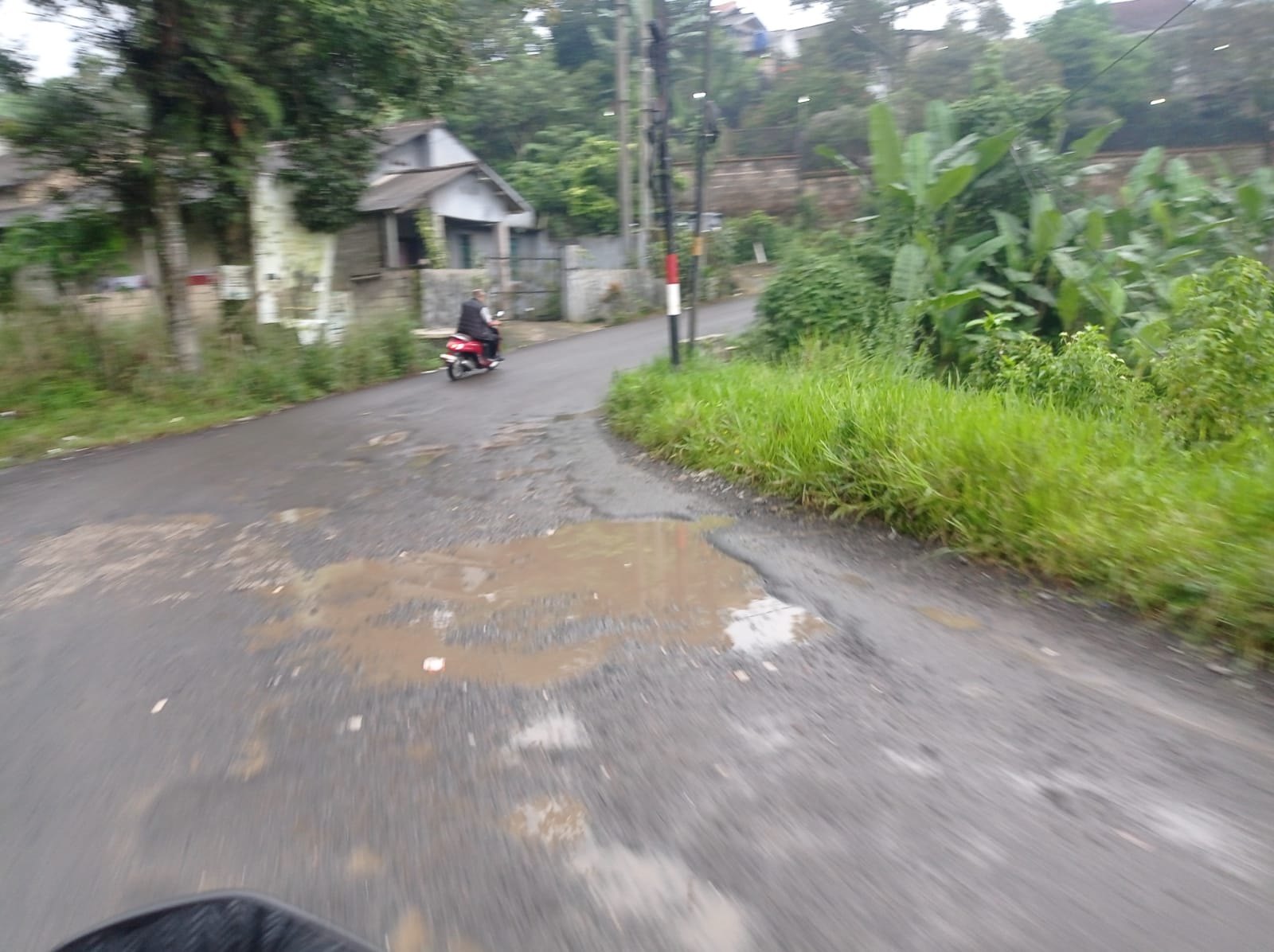 Kondisi akses jalan menuju kawasan wisata di Desa Sukajadi, Kecamatan Tamansari, Kabupaten Bogor, yang rusak.
