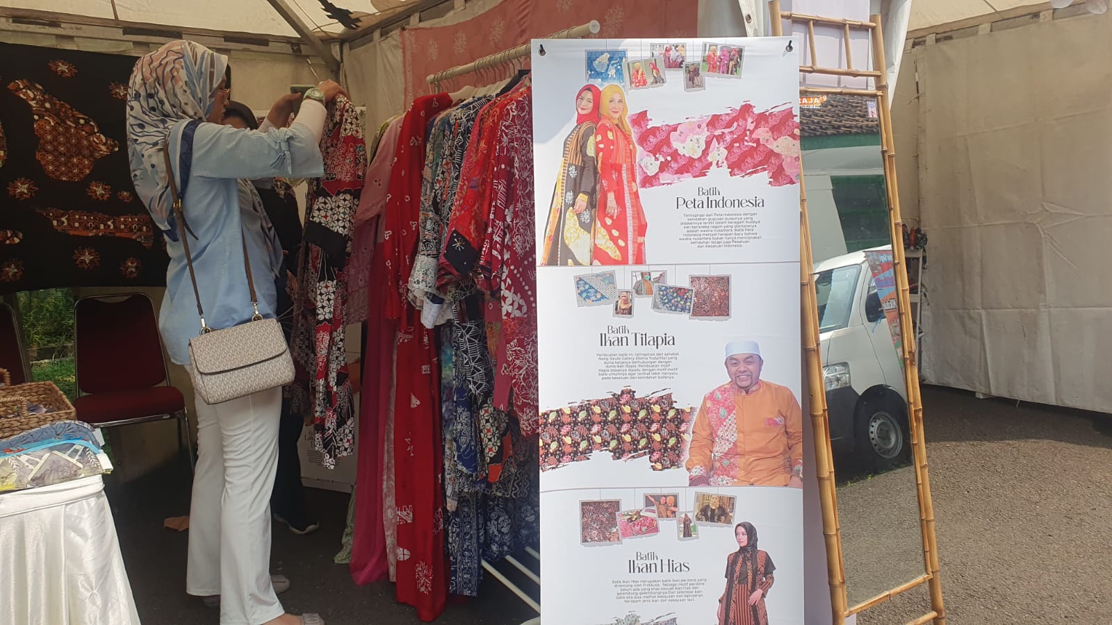 Tim Frida Aulia Indonesia mendampingi pengunjung yang melihat koleksi di stand bazar HJB ke-542.
