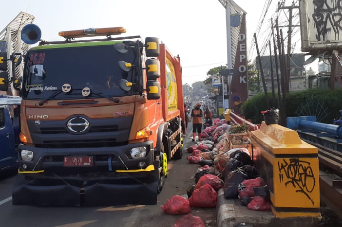 Petugas kebersihan dari UPT Kebersihan Wilayah V Parung tengah bersiap mengangkut sampah liar.