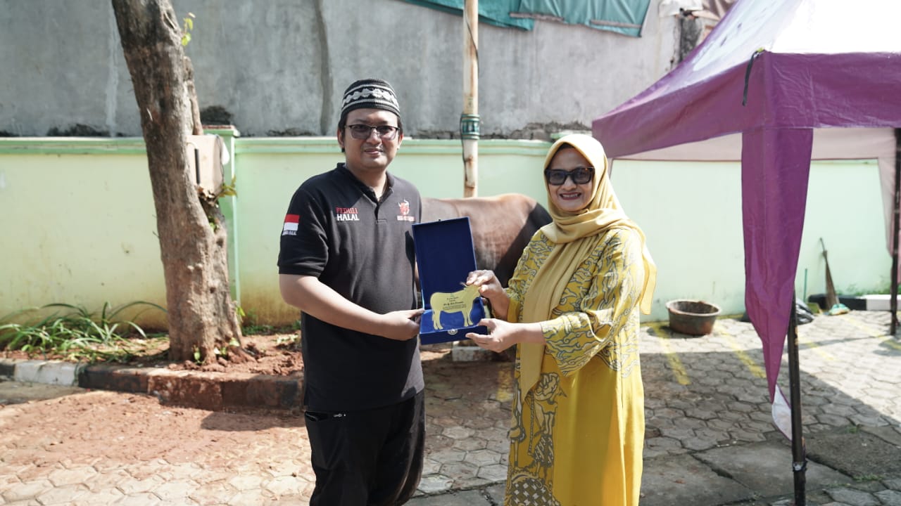 Presiden Direktur & CEO XL Axiata, Dian Siswarini (kanan) menyerahkan secara langsung hewan kurban miliknya kepada Ketua DKM Musholla An-Nur Syafa