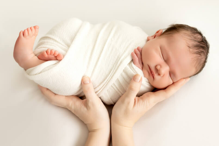 Ilustrasi membedong bayi